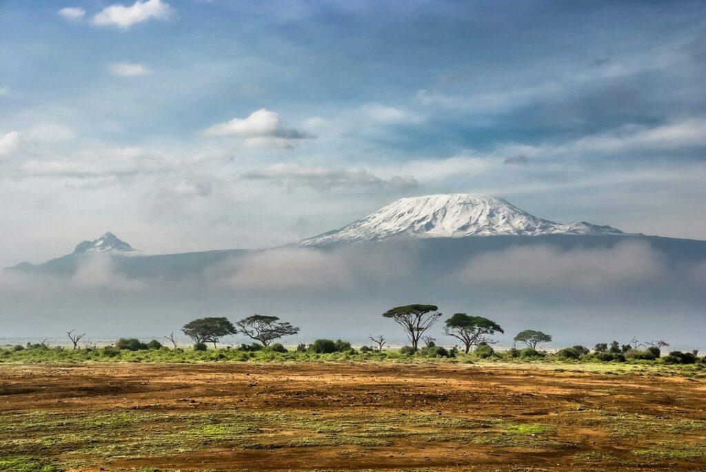 Mount Kilimanjaro with a snow-capped peak above clouds in Amboseli National Park